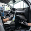 Aplicación de spray TUNAP 996 en el compartimento del filtro de polen del coche por un mecánico.